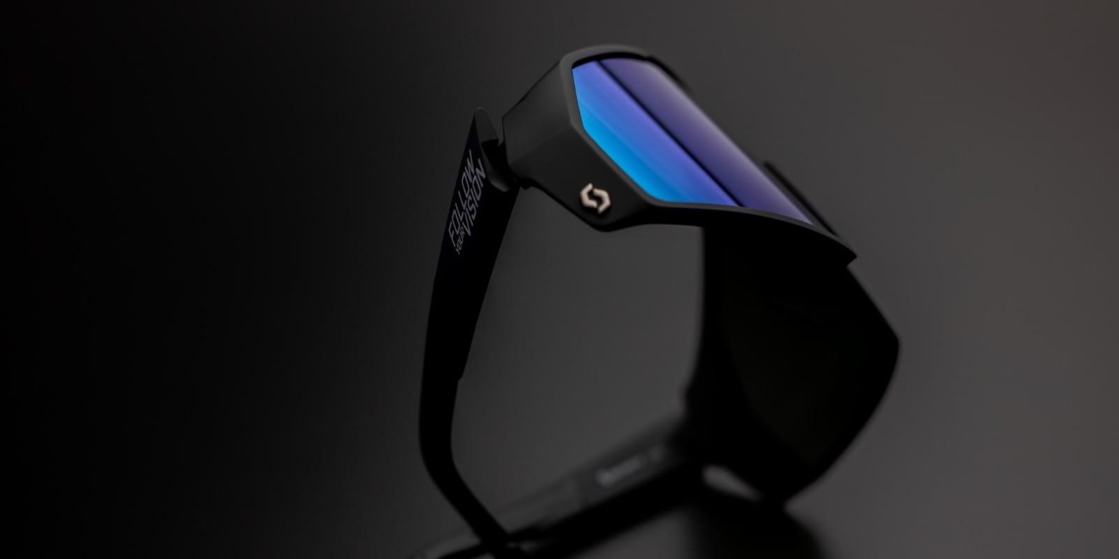 SCOTT Pro shield follow your vision sunglasses beauty shot, on a grey background, showing a blue to violet reflect on the lens