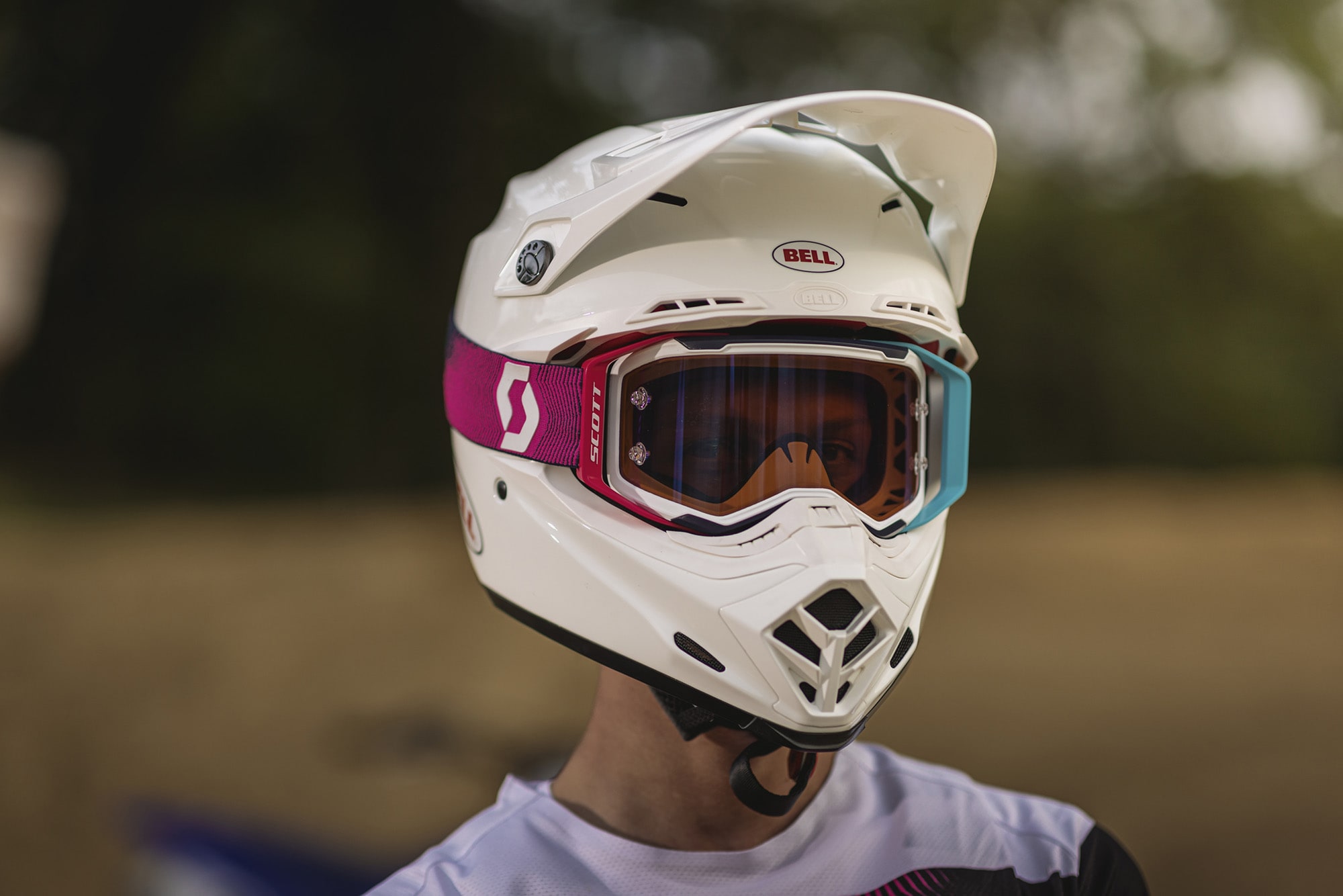 rider wearing a white helmet and a pink and sky blue goggle