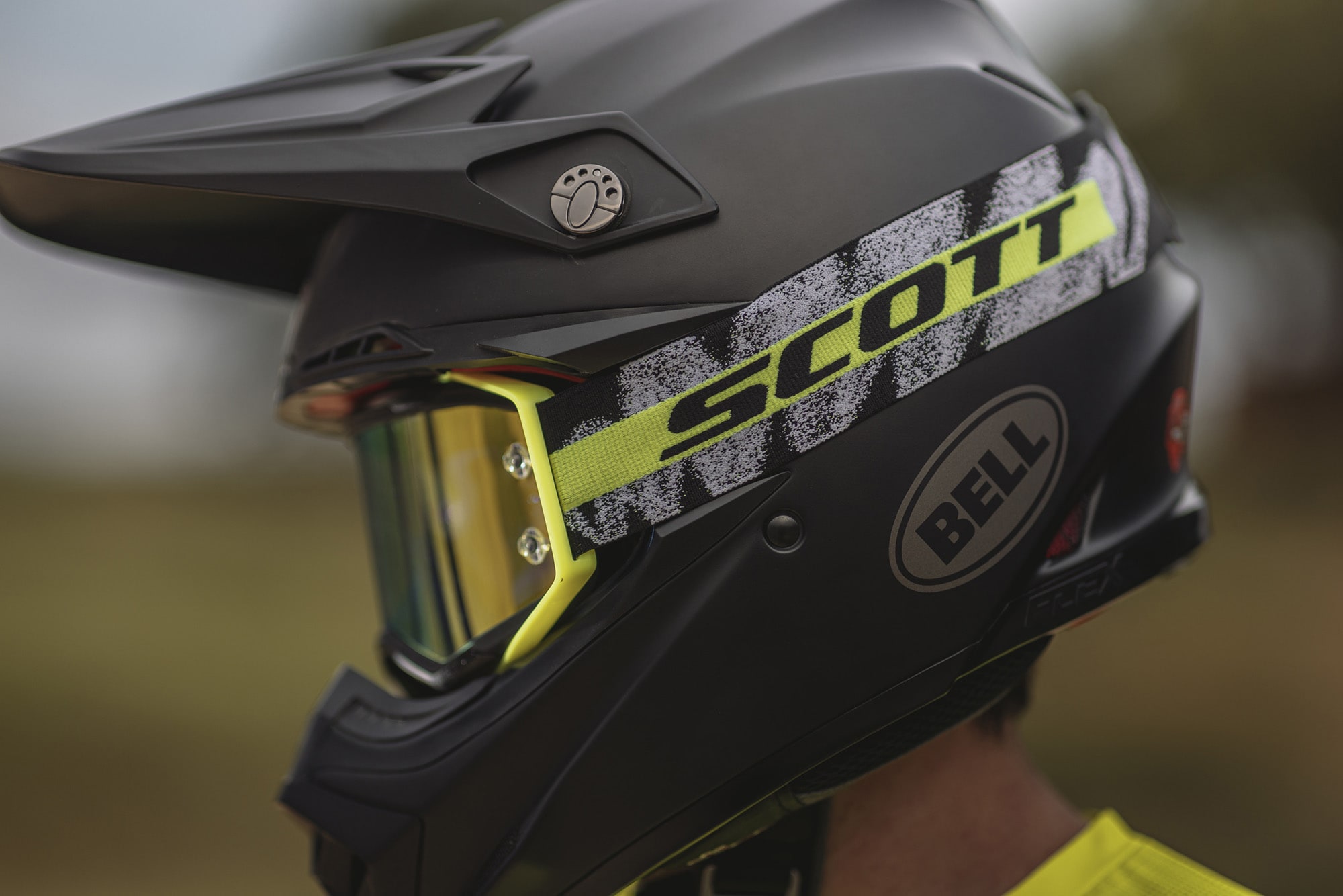 close-up shot of a rider wearing a black helmet with a black and neon yellow goggle